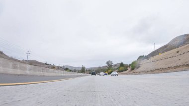 Yağmurlu bir kış gününün ortasında, Los Angeles, Kaliforniya yakınlarındaki HWY 134 'te, yağmur damlalarıyla kaplı lenslerle atmosferi yakalıyor, ve bu yolculuğa benzersiz ve dengesiz bir perspektif ekliyor..