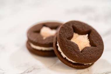 Yakından bakıldığında çikolatalı sandviç kurabiyelerinin yıldız şekilli ve şekerli olduğu görülüyor. Işıklandırma pürüzsüz dolgu dokusunu vurgular.