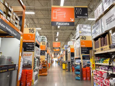 Süpürge Sahası, CO, ABD-16 Kasım 2025 - Bu editoryal görüntü, üzerinde su tesisatı ve musluk tabelası olan bir nalbur dükkanı koridorunu gösteriyor. Her iki taraftaki raflarda da çeşitli malzemeler var.