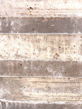 Dökülen beton duvarın yakın plan görüntüsü yatay çizgiler ve ince yüzey varyasyonları. Duvar dokusu modern mimarinin ham endüstriyel sonunu vurgular..