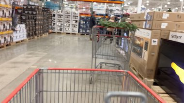 Parker, Colorado, ABD-29 Kasım 2024 - Broomfield 'daki Costco reyonuna geniş bir bakış açısı bir alışveriş gezisi sırasında televizyon ve tatil eşyaları yakınında bir el arabası gösteriyor.