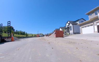 Castle Rock, CO, ABD-18 Haziran 2025 - Castle Rock, Colorado 'da inşaat halindeki bir mahalle caddesinin görüntüsü. Taze asfalt ve inşaat malzemeleri açık mavi bir gökyüzünün altında görülebilir.