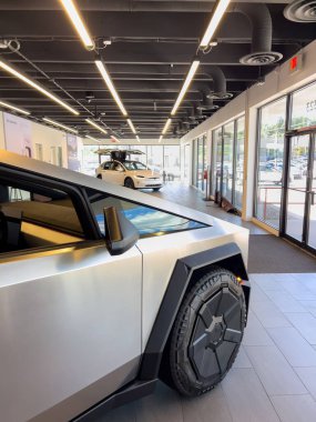 Colorado Springs, CO, ABD-1 Ekim 2025 - Bir Tesla Siber Kamyonu lüks modern ışıklandırmalı bir galeri galerisinde sergileniyor. Kamyonun açısal çizgileri ve kalın tekerlekleri vurgulanıyor
