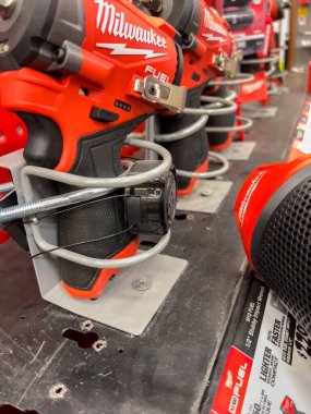 Süpürge alanı, CO, USA-8 Aralık 2025 - Her bir ünitenin etrafına metal güvenlik parantezleri sarılmış bir mağaza standında elektrikli aletler sergilenmektedir. Parlak kırmızı ve siyah alet gövdeleri bir karşı oturur