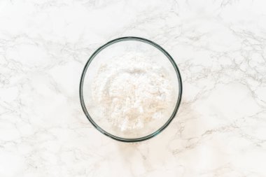 Cam kase, pürüzsüz bir krema ile karıştırılmaya hazır, basit beyaz saray şekerlemesi için gereken tüm malzemeleri içeriyor..