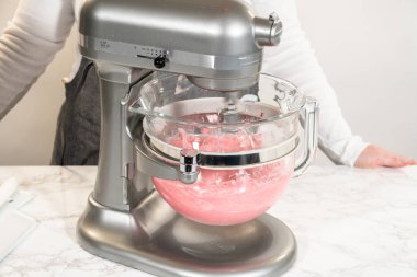 Böğürtlen kreması malzemelerini karıştırmak için bir stand mikseri kullanılır. Karışım, zengin, kremalı dokularla limonlu kurabiyeler için canlı krema için bir parça kızılcık karışımını birleştiriyor..