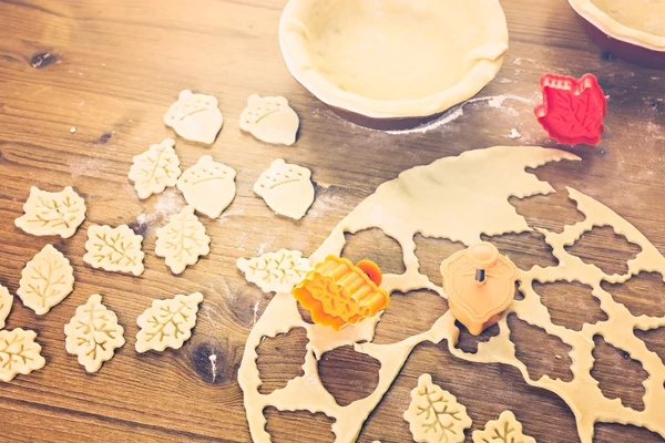 Cutting out Autumn leafs, pumpkin pie — Stock Photo, Image