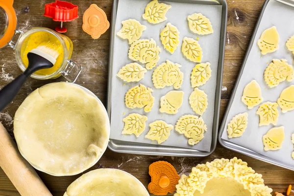 Cutting out Autumn leafs, pumpkin pie — Stock Photo, Image