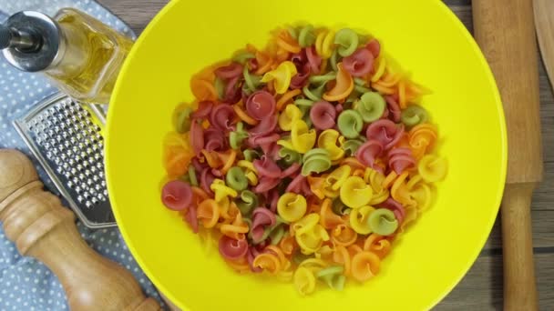 Pasta multicolored spiral fall from above. Close up of raw spaghetti red, yellow, green color background, italian food — Stock Video