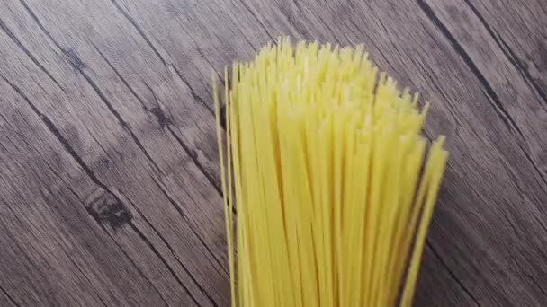 De spaghetti brokkelt af en valt op de houten tafel. slow motion — Stockvideo