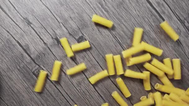 Spaghetti kruszy się i spada na drewniany stół. zwolniony ruch — Wideo stockowe