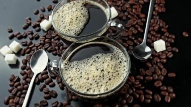Kahve çekirdekleri ve karika çubukları üzerinde kahve ile iki fincan döndürmek