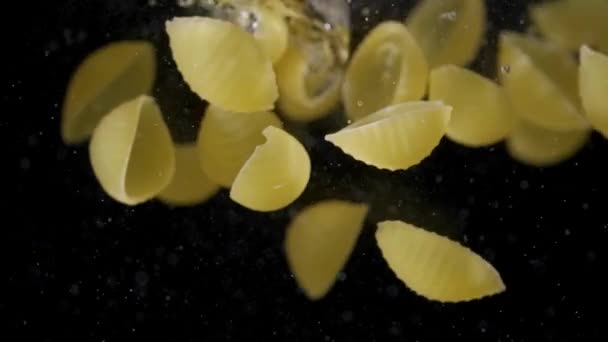 Pasta cayendo en agua hirviendo. Pasta cayendo en el agua fue disparada en cámara lenta — Vídeos de Stock