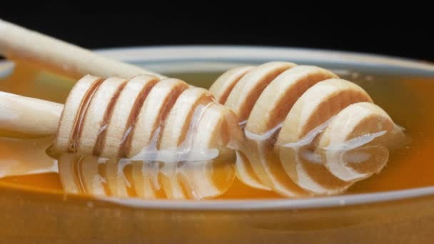 Натуральний чистий мед. Влийте дерев'яну ложку в тарілку з медом, обертається в колі . — стокове відео