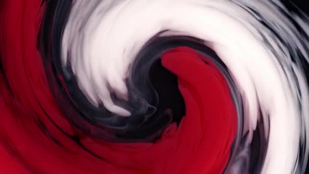Vermischte rote und weiße Tinte gemischt mit Wasser auf schwarzem Hintergrund, während sie wunderschöne Wirbelformen schafft. — Stockvideo