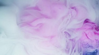 Suda beyaz ve kırmızı mürekkep, boya karışımı. Renkli kırmızı ve beyaz boya damlaları suya karışıyor..