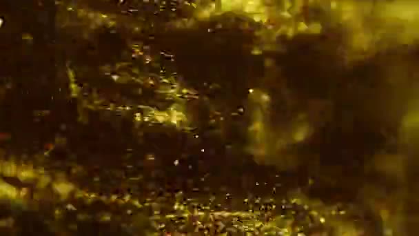 Zlatý inkoust ve vodě s rychlokamerou. Zlaté kapky barvy kapky, reagující, vytváří abstraktní mraky formace metamorfózy na černé. — Stock video