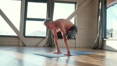Güçlü yoga egzersizleri yapan olgun bir adam..