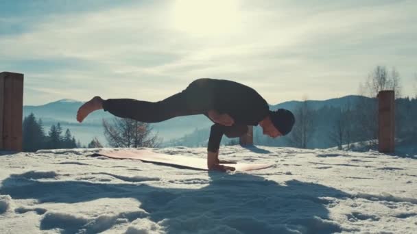 Kafkasyalı son sınıf öğrencisi kış dağlarında gün batımının önünde yoga egzersizleri yapıyor. — Stok video