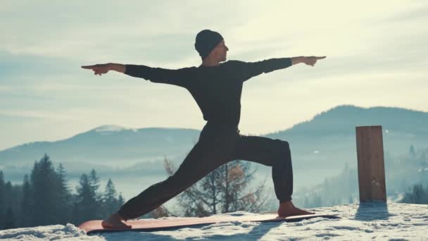 Kafkasyalı son sınıf öğrencisi kış dağlarında gün batımının önünde yoga egzersizleri yapıyor. — Stok video