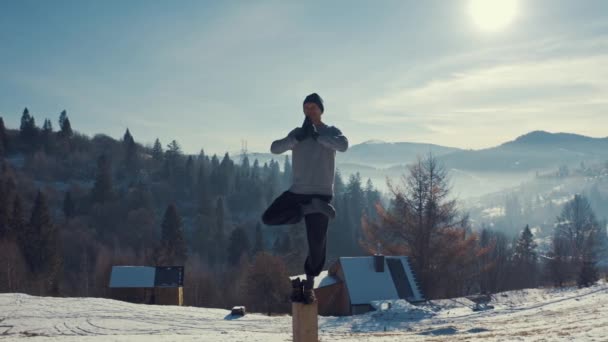 Dağın tepesindeki sporcu esneme hareketleri yapıyor. Kışın antrenman. hava görünümü — Stok video