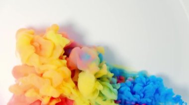 Sudaki renkli mürekkebe mürekkep damlayan mürekkep rengi, 4K görüntü, kırmızı mavi turuncu sarı. beyaz arkaplan