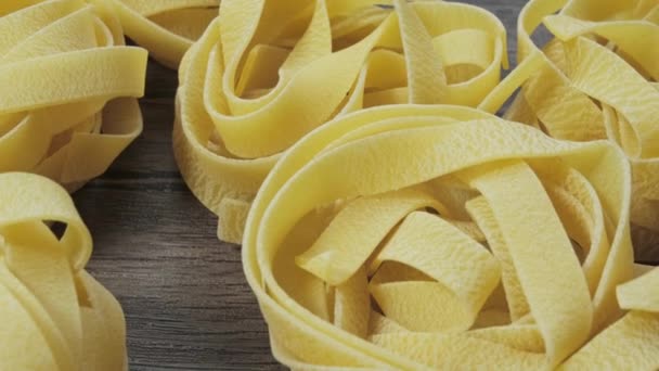 На борту обертаються сирі макарони. Fettuccine, tagliatelle pasta. Італійська кухня. Походження їжі — стокове відео