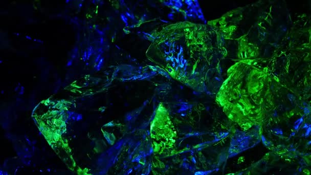 Block ice is lit with green neon in the light. rotates creating different highlights — Stock Video