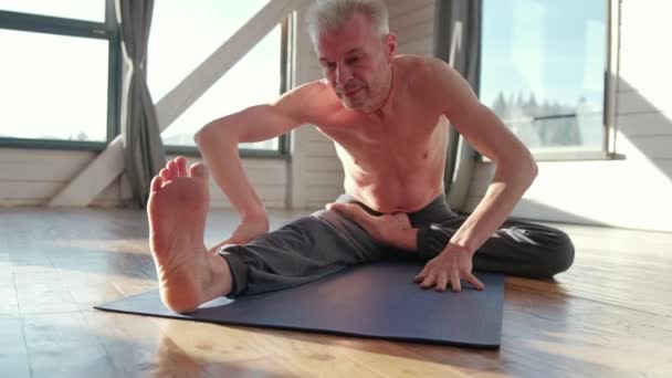 Hombre maduro entre hacer ejercicios de yoga de poder pierna. — Vídeos de Stock