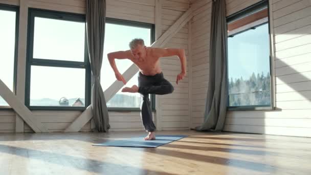 Atletico e bello uomo maturo che pratica yoga asana — Video Stock