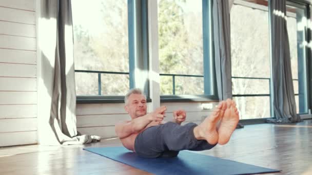 Homme mûr parmi faire des exercices de yoga de puissance. — Video