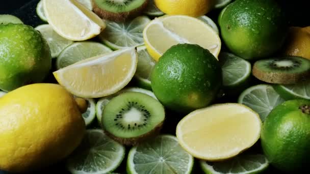 Variedad de cítricos incluyendo limones, limas, kiwi. Vista superior giratoria — Vídeo de stock