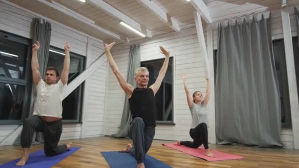 Groep mensen die yoga doen in de hal. — Stockvideo