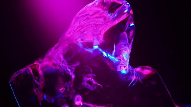 Blok ijs wordt verlicht met neon blauw en roze in het licht. roteert het creëren van verschillende highlights — Stockvideo