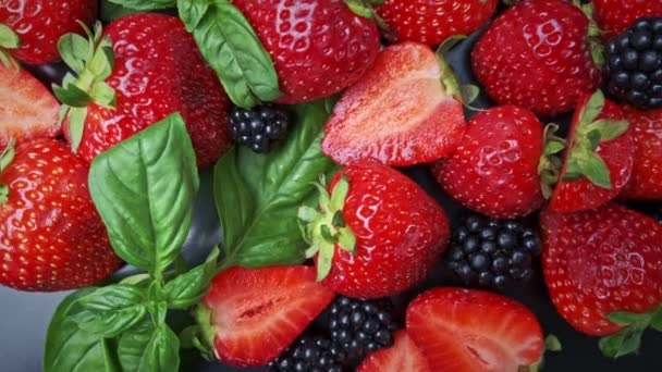 黑色背景的野生森林浆果，草莓、蓝莓和黑莓的集合. — 图库视频影像