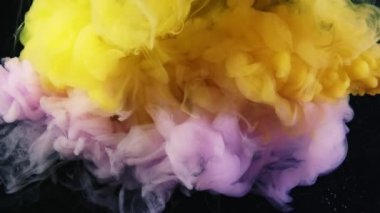 Pembe ve sarı akrilik boya siyah arkaplanda suda hareket ediyor