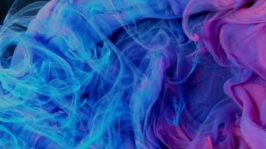 Cloud of silky ink in water isolated on black background. Colorful ink in water, ink drop. Purple, blue, pink.