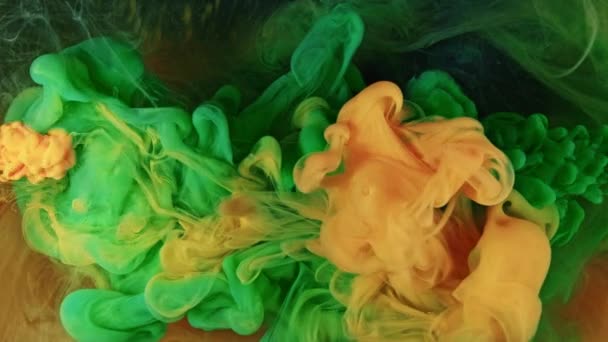 Inchiostro in acqua che si fonde insieme. Verde e arancione — Video Stock