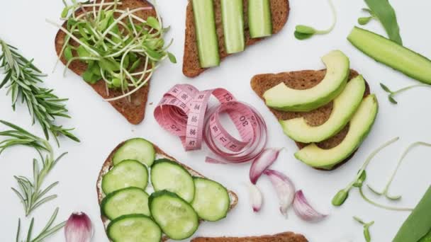 Peynirli ekmek, sebze ve otlar beyaz arka planda. sağlıklı gıda zayıflatma konsepti — Stok video