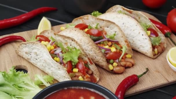 El plato mexicano de torta plana de maíz Tako con relleno de verduras en una tabla de madera — Vídeo de stock