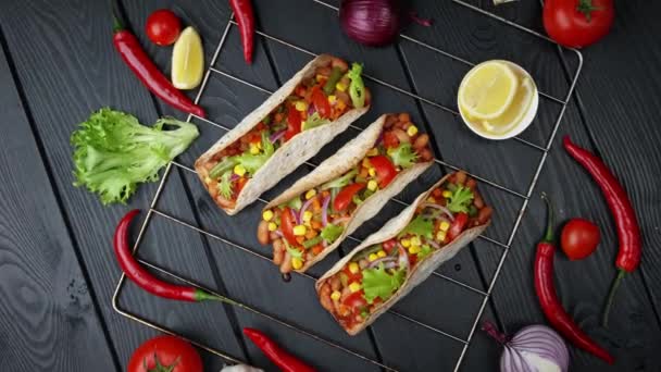 Traditionell mexikansk mat. Smaklig tacos med grönsaker. Färgglada ingredienser på svart bakgrund — Stockvideo