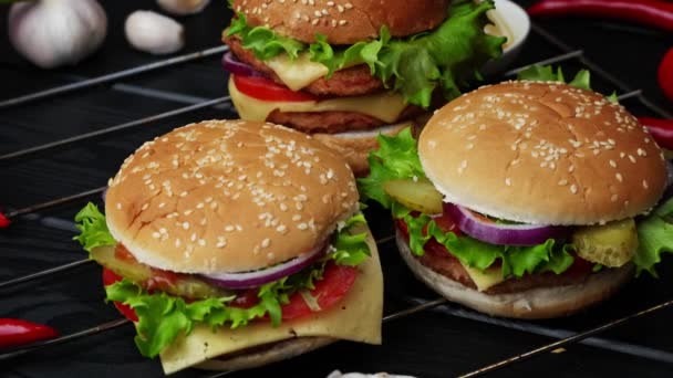 Vegetariánské burgery na černém pozadí, detailní záběr — Stock video