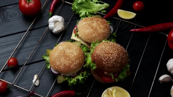 Burger vegetarian dengan latar belakang hitam dengan sayuran yang berbeda. Lihat dari atas — Stok Video