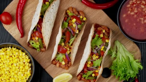 Comida tradicional mexicana. Sabrosos tacos con verduras. Ingredientes coloridos sobre fondo negro — Vídeos de Stock