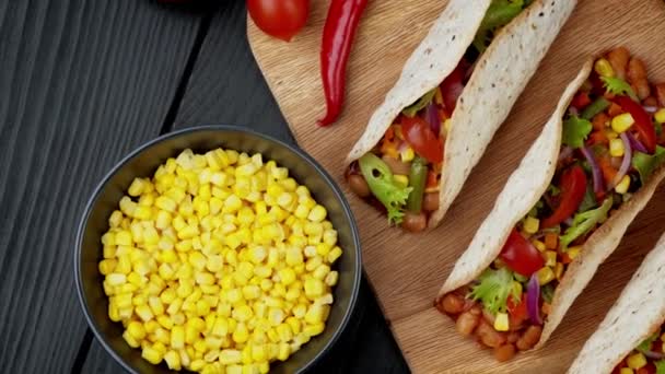 Comida mexicana tradicional. Tacos saborosos com vegetais. Ingredientes coloridos sobre fundo preto — Vídeo de Stock