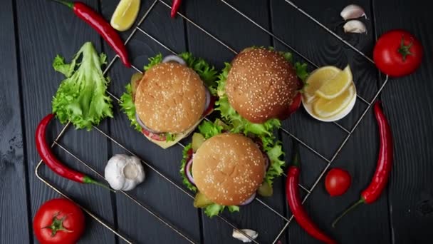 Hamburguesas vegetarianas sobre fondo negro con diferentes verduras. Vista desde arriba — Vídeo de stock