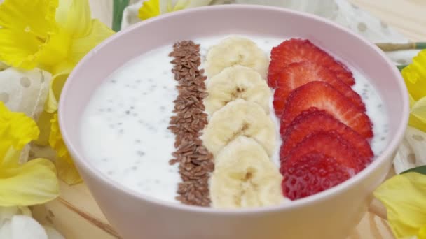 Granola met yoghurt voor ontbijt met fruit, bessen, een kopje. Havermout met aardbeien en banaan. Gezond ontbijt concept. Uitzicht van bovenaf, Close up — Stockvideo