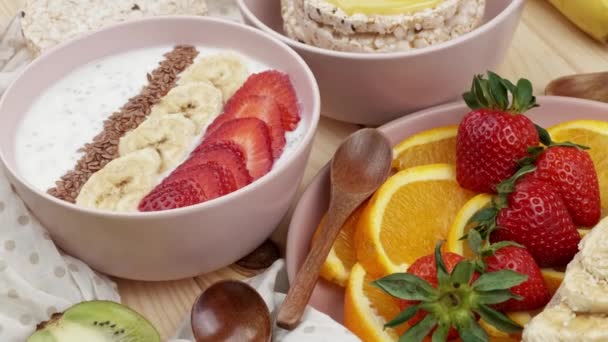 Granola con yogur para el desayuno con frutas, bayas, una taza. Harina de avena con fresas y plátano. Concepto de desayuno saludable. Vista desde arriba — Vídeos de Stock