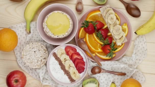 Granola con yogur para el desayuno con frutas, bayas, una taza. Harina de avena con fresas y plátano. Concepto de desayuno saludable. Vista desde arriba — Vídeos de Stock