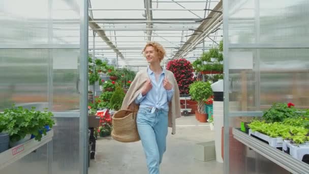 Curly mulher loira comprando plantas decorativas no mercado de estufa florística. Conceito de Casa e Jardim. — Vídeo de Stock
